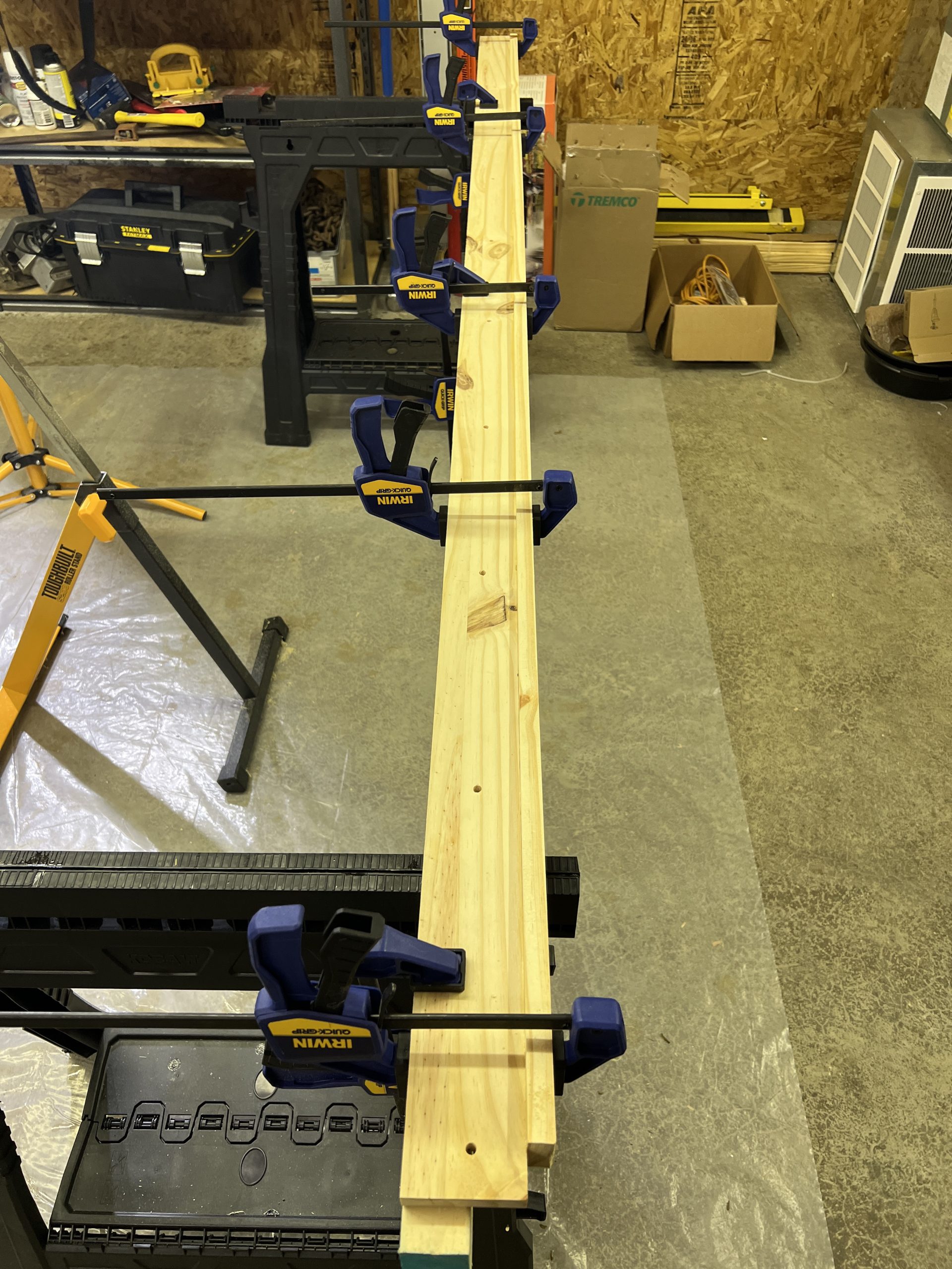 The large jig is a 87 inch board with several holes properly spaced. The jug is shown clamps that are holding everything together while the glue dries.