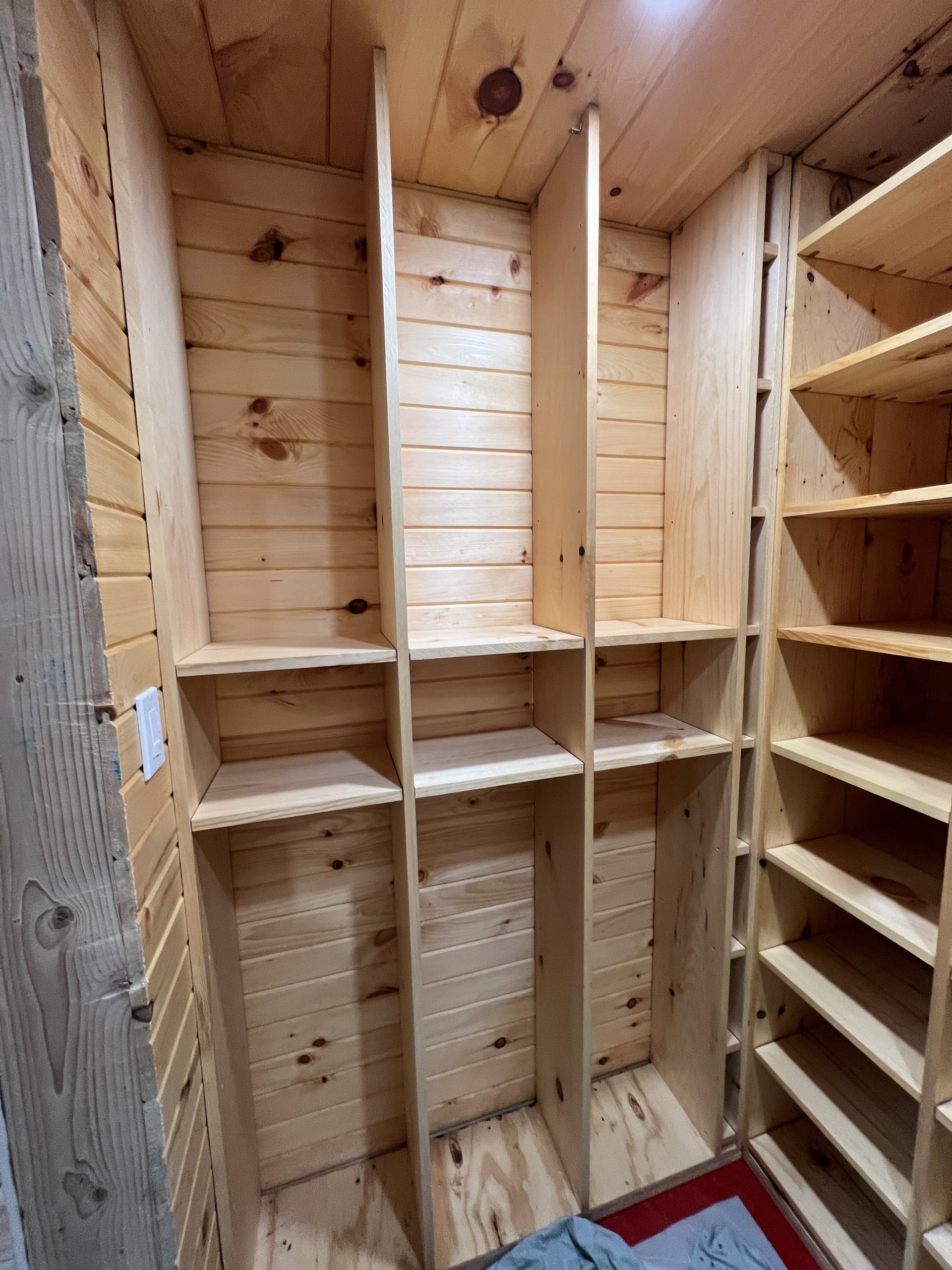 A partially assembled wall of wine bins built out of 1x10 pine boards.