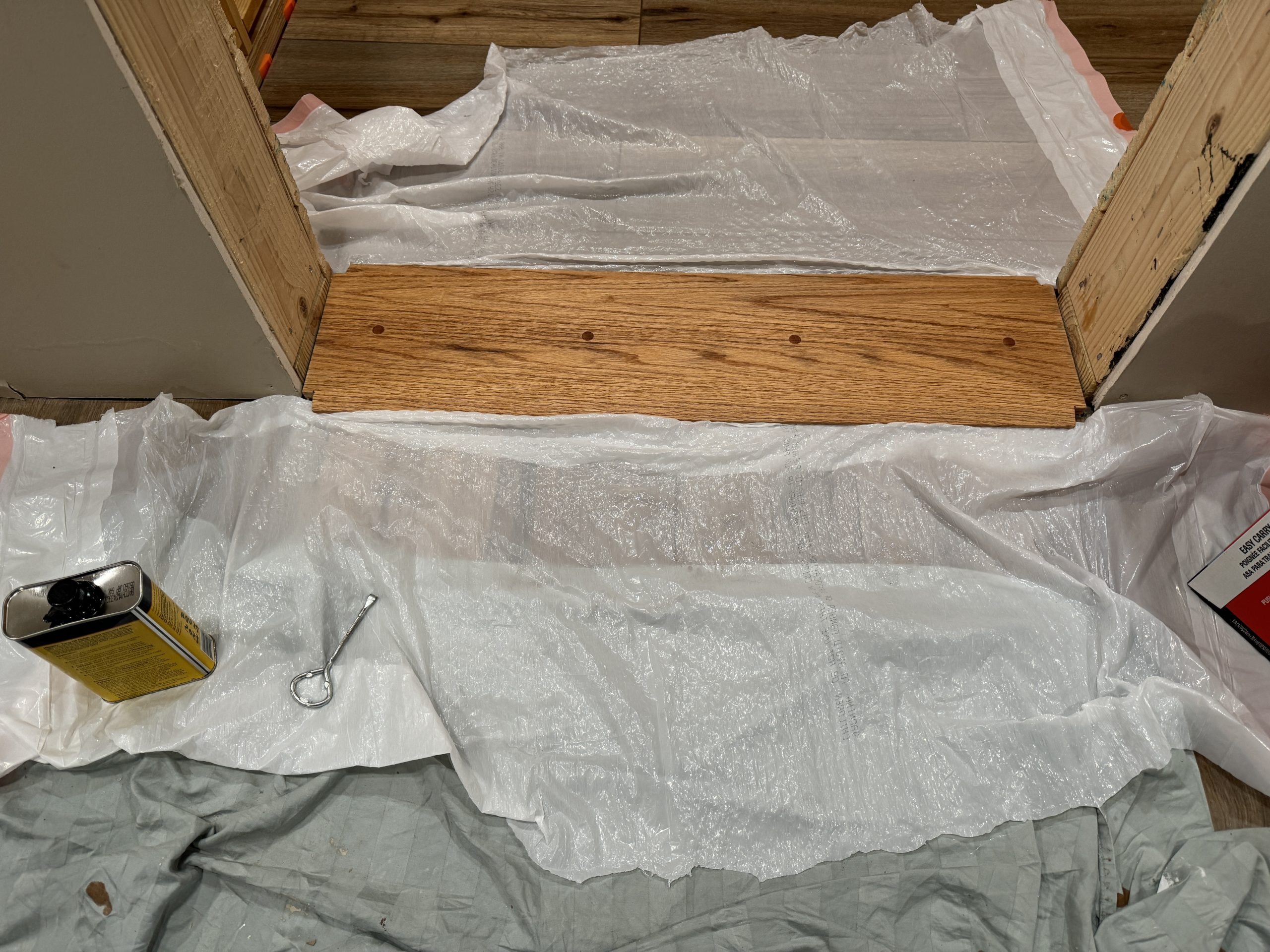 An oak door threshold surrounded by drop cloths.